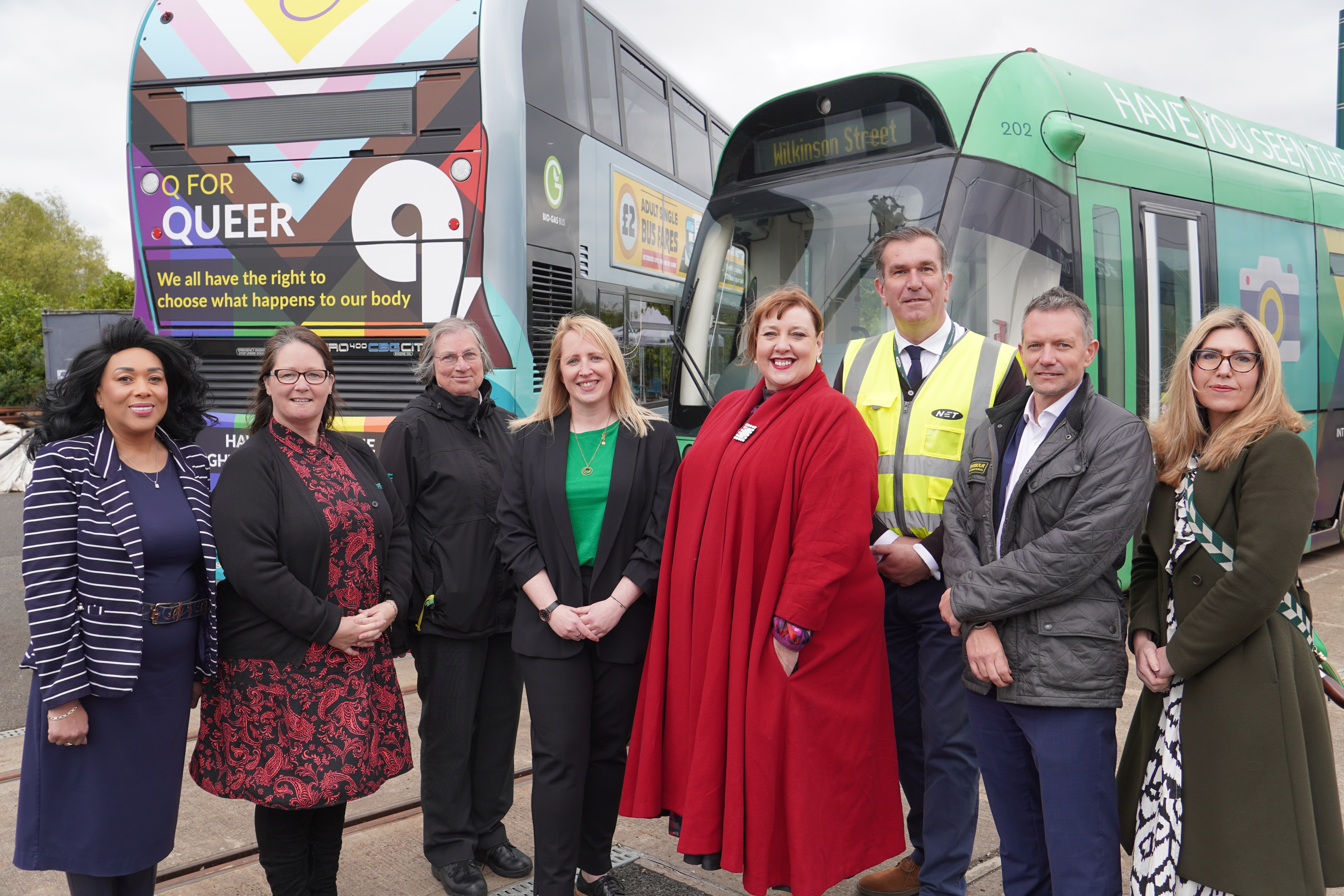 Members of the Consent Coalition stand in front of NCT bus and trams showing the edgy campaign