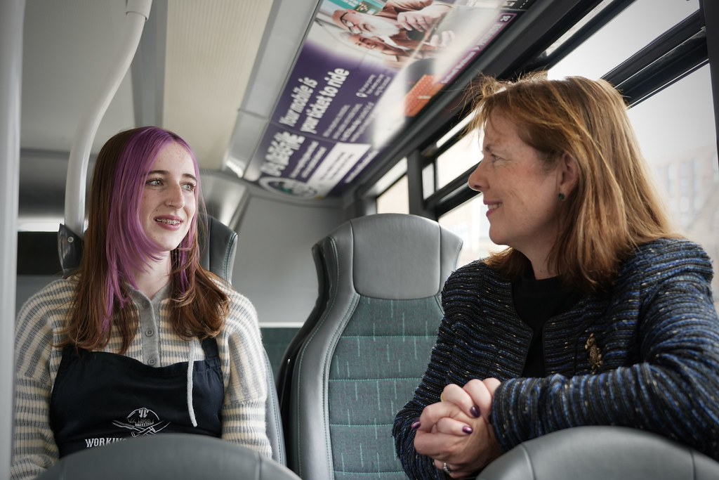 Mayor Claire on an NCT bus talking to a young girl.